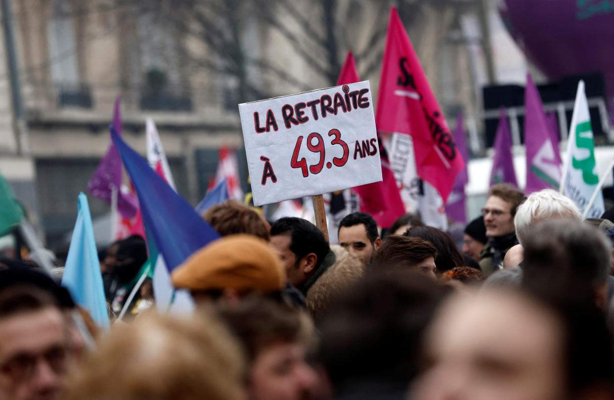 Des manifestants pointent une pancarte en référence à l'article 49.3 de la Constitution lors de la journée de mobilisation du 19 janvier 2023 contre la réforme des retraites (crédit :REUTERS/Benoit Tessier)