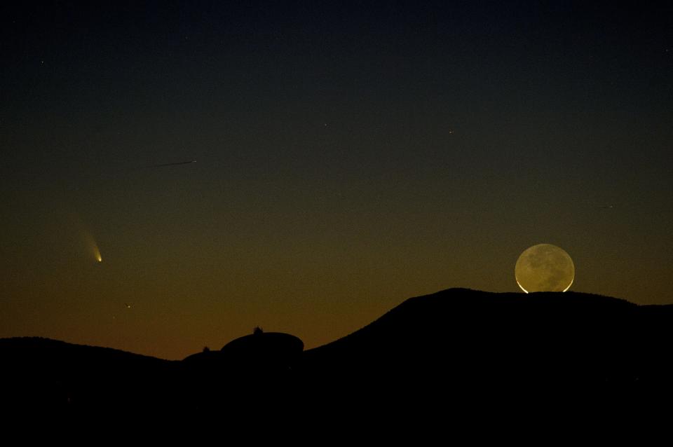 Comet PanSTARRS (L) is seen with a one-day old crescent moon as both set over the Very Large Array radio telescope antenna dishes March 12, 2013 near Magdalena, New Mexico. The comet, now just faintly visible in the northern hemisphere, was discovered in June 2011 by the Panoramic Survey Telescope and Rapid Response System (PanSTARRS) in Hawaii. AFP PHOTO/Stan HONDA        (Photo credit should read STAN HONDA/AFP/Getty Images)