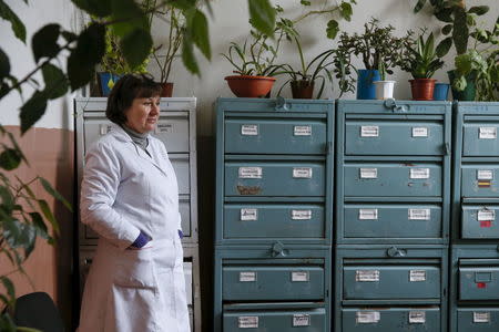 A doctor stands next to file cabinets containing the medical cards of patients at a clinic in the village of Staiky, south of Kiev, Ukraine, November 9, 2015. REUTERS/Valentyn Ogirenko