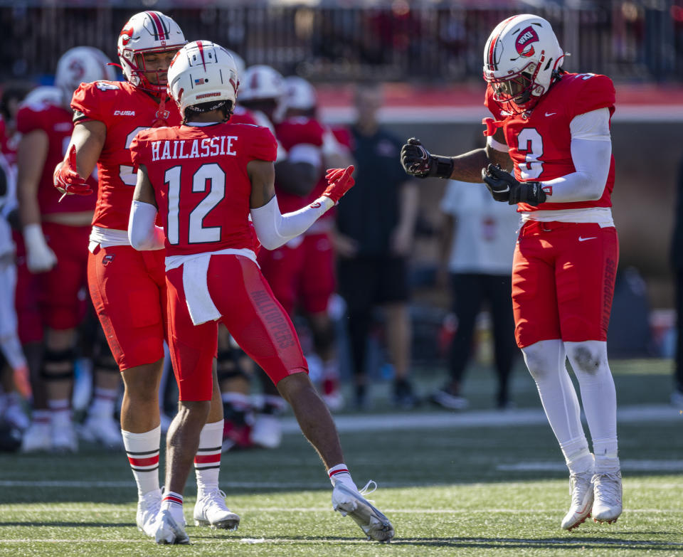 WKU defensive back Kahlef Hailassie, 12, celebrates with teammates Juwuan Jones, 34, left, and JaQues Evans, 3, right, after Hailassie intercepted a pass during an NCAA football game between Western Kentucky University and Florida International University on Saturday, Sept. 24, 2022, in Bowling Green, Ky. WKU beat FIU 73-0. (AP Photo/James Kenney)