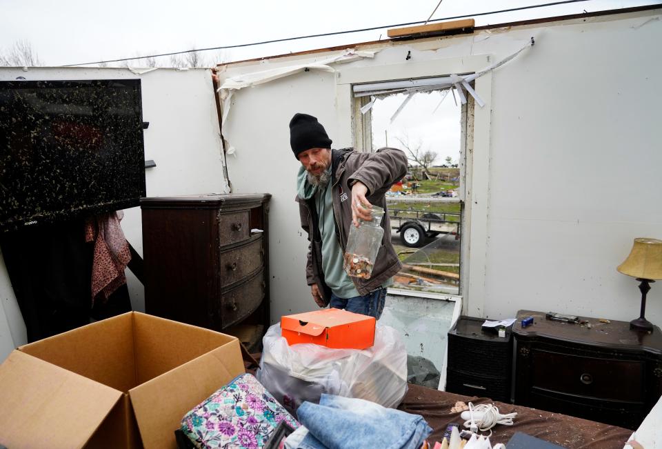 Travis Gause sifts through belongings in his home in Lakeview, Ohio, following a tornado the night before, Friday, March 15, 2024. Travis and his wife, Tanya, along with their dogs, sheltered in their bathroom.