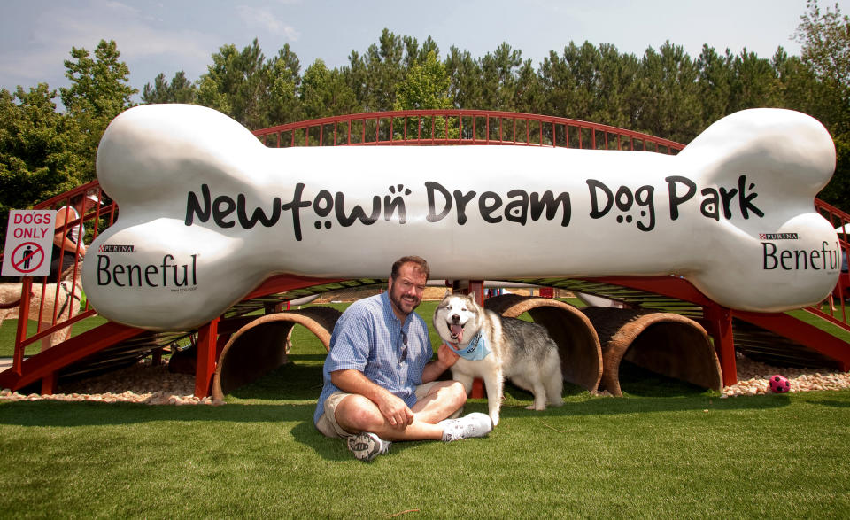 This June 15, 2011 photo released by Beneful shows Grand Prize Winner of the 2010 Beneful Dream Dog Park Contest, Pat McNeely and Koda, at the unveiling of their Dream Dog Park in Johns Creek, Ga . The dog park offers water splash pads, a 3-D dog bone bridge and crawl tunnels. (AP Photo/Beneful)