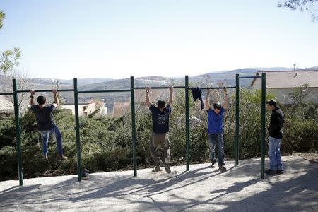 Students do pull-ups as they train at the Bnei David academy, the first religious military prep school and Jewish seminary, in the West Bank Jewish settlement of Eli, south of Nablus, January 31, 2016. REUTERS/Ronen Zvulun