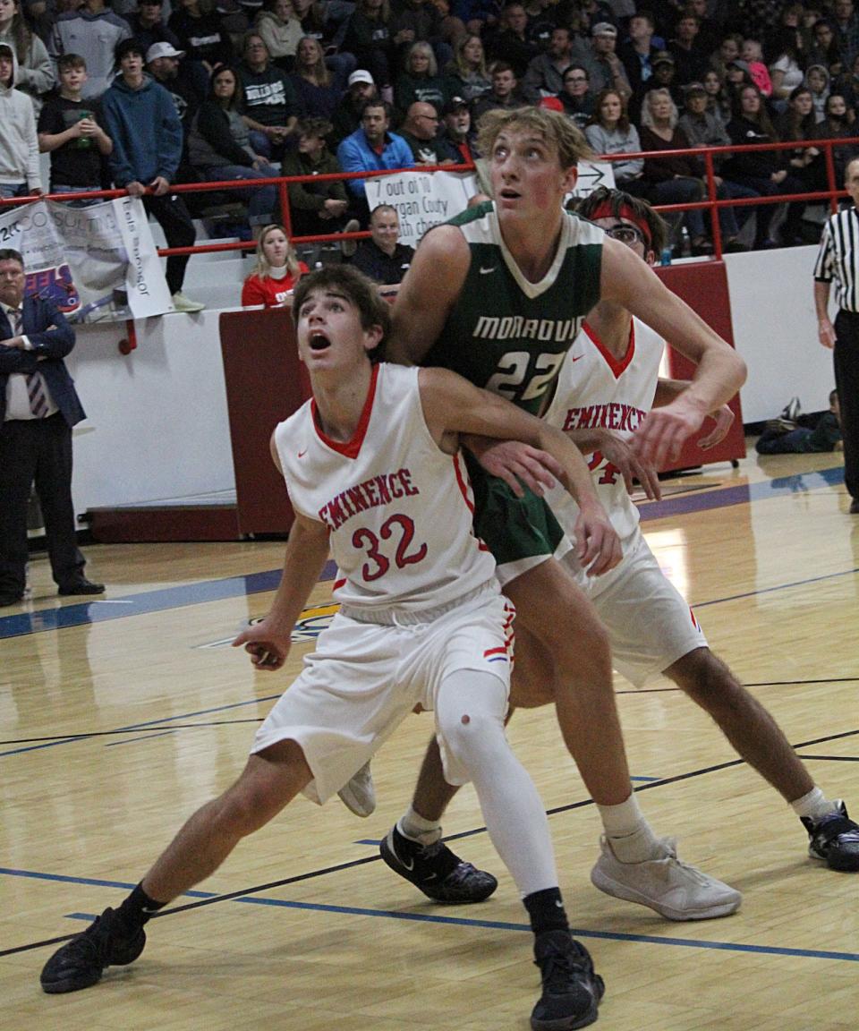 Monrovia senior Austin Leeds (22) and Eminence junior Hayden Holley (32) battle for a rebound during Wednesday's Powder Keg game at Eminence. 