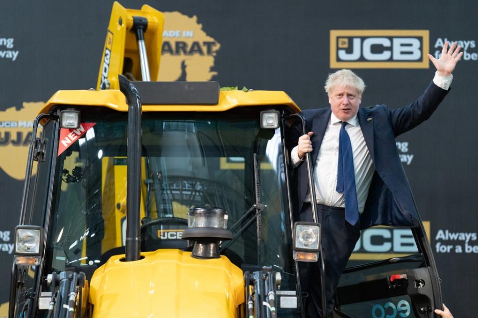 Boris Johnson climbs over a JCB at the new factory in Vadodara, Gujarat (Stefan Rousseau/PA) (PA Wire)