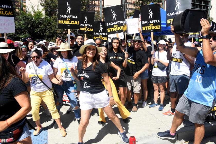 A woman dancing in front of a crowd with signs