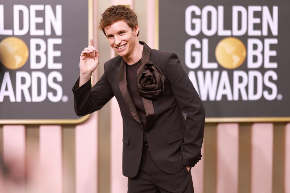 Eddie Redmayne se pone un esmoquin marrón Valentino adornado con una boutonnière de gran tamaño.