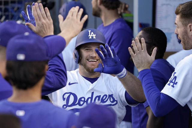 Los Angeles Dodgers' Max Muncy is congratulated by teammates in the dugout after hitting a solo home run during the second inning of a baseball game against the San Diego Padres Friday, July 1, 2022, in Los Angeles. (AP Photo/Mark J. Terrill)