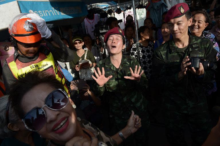 Soldiers dance with residents at a military event organised to 'return happiness to the people' at Victory Monument, the site of recent anti-coup rallies in Bangkok, on June 4, 2014