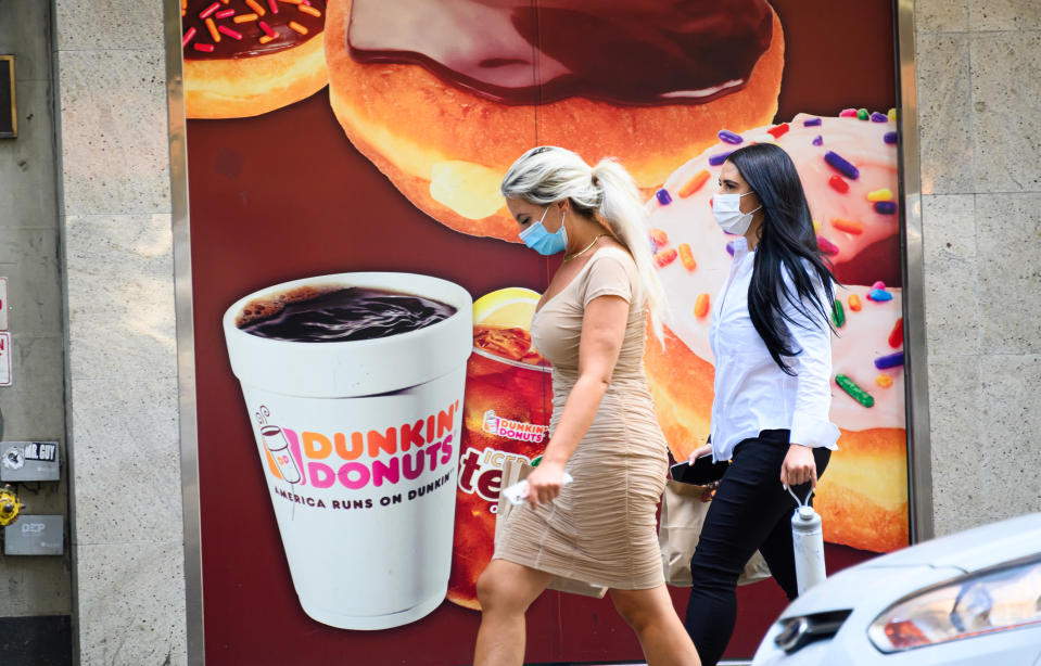 People wear protective face masks outside Dunkin' Donuts on the Upper West Side as the city continues Phase 4 of re-opening following restrictions imposed to slow the spread of coronavirus on July 28, 2020 in New York City. (Noam Galai/Getty Images)