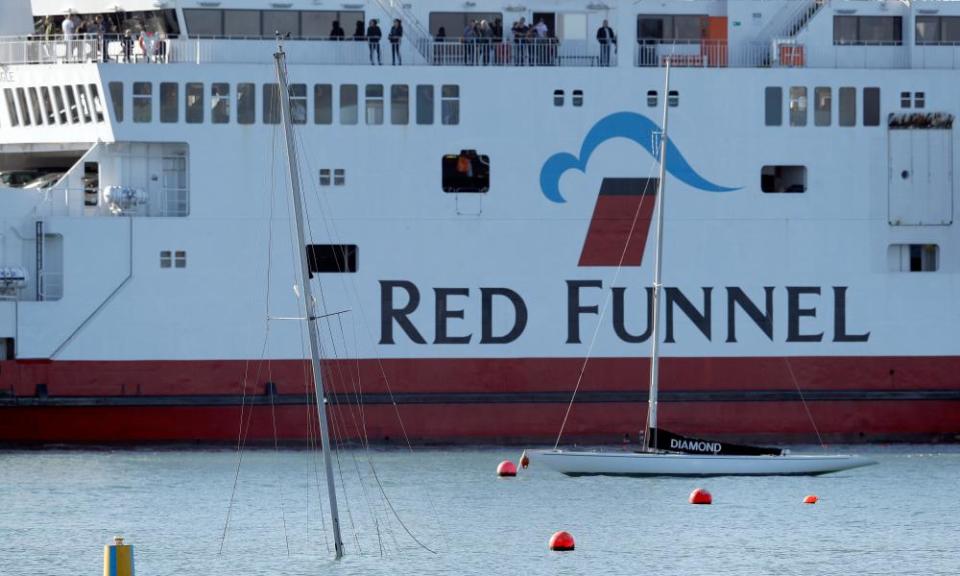 A Red Funnel ferry near the semi-submerged mast of a yacht that sank after the collision at East Cowes, Isle of Wight.