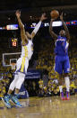 Los Angeles Clippers' Jamal Crawford, right, makes a 3-point basket over Golden State Warriors' Andre Iguodala during the first half in Game 3 of an opening-round NBA basketball playoff series Thursday, April 24, 2014, in Oakland, Calif. (AP Photo/Marcio Jose Sanchez)