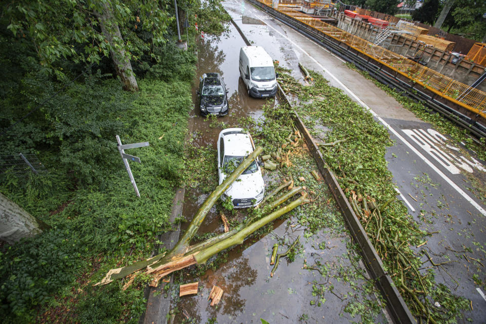 A tree hit a car and block a street after a storm in Stuttgart, Germany, Tuesday, June 29, 2021. Thunderstorms hit Germany late Monday and torrential rains poured down on the southern and western parts of the country leading to dozens of accidents and hundreds of firefighter operations throughout the night. ( Simon Adomat/VMD-Images/dpa via AP)