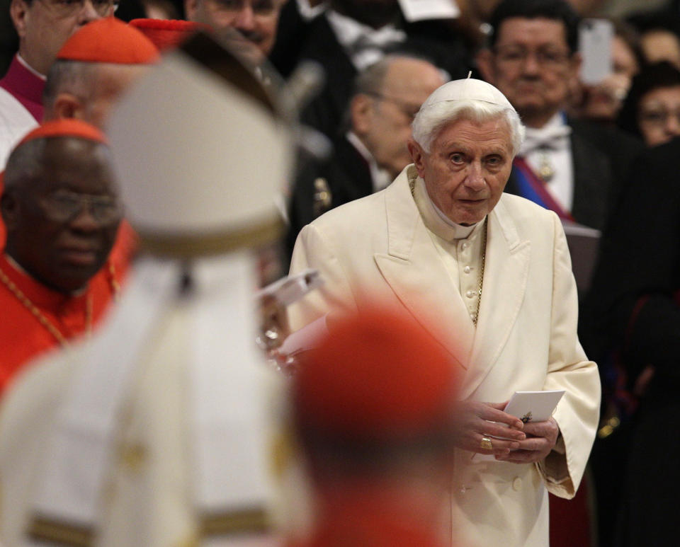 Pope Emeritus Benedict XVI looks at Pope Francis, left with back to camera, arriving as he attends a consistory inside the St. Peter's Basilica at the Vatican, Saturday, Feb.22, 2014. Benedict XVI has joined Pope Francis in a ceremony creating the cardinals who will elect their successor in an unprecedented blending of papacies past, present and future. (AP Photo/Alessandra Tarantino)