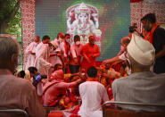 Hindus offer prayers for a groundbreaking ceremony of a temple dedicated to the Hindu god Ram in Ayodhya, at the Vishwa Hindu Parishad, or World Hindu Council, headquarters in New Delhi, India, Wednesday, Aug. 5, 2020. The coronavirus is restricting a large crowd, but Hindus were joyful before Prime Minister Narendra Modi breaks ground Wednesday on a long-awaited temple of their most revered god Ram at the site of a demolished 16th century mosque in northern India. (AP Photo/Manish Swarup)