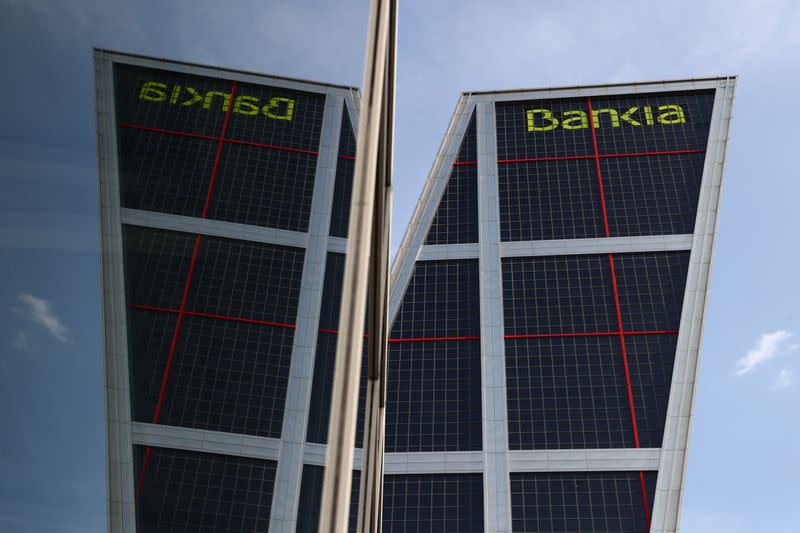 Headquarters of Spanish lenders Bankia is reflected in a window in Madrid