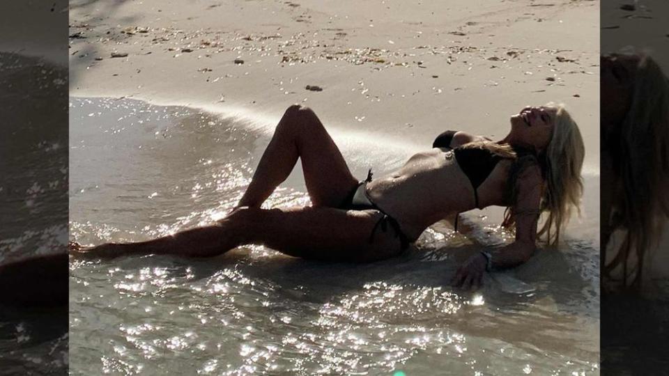 Christie Brinkley lies on the beach in a bikini