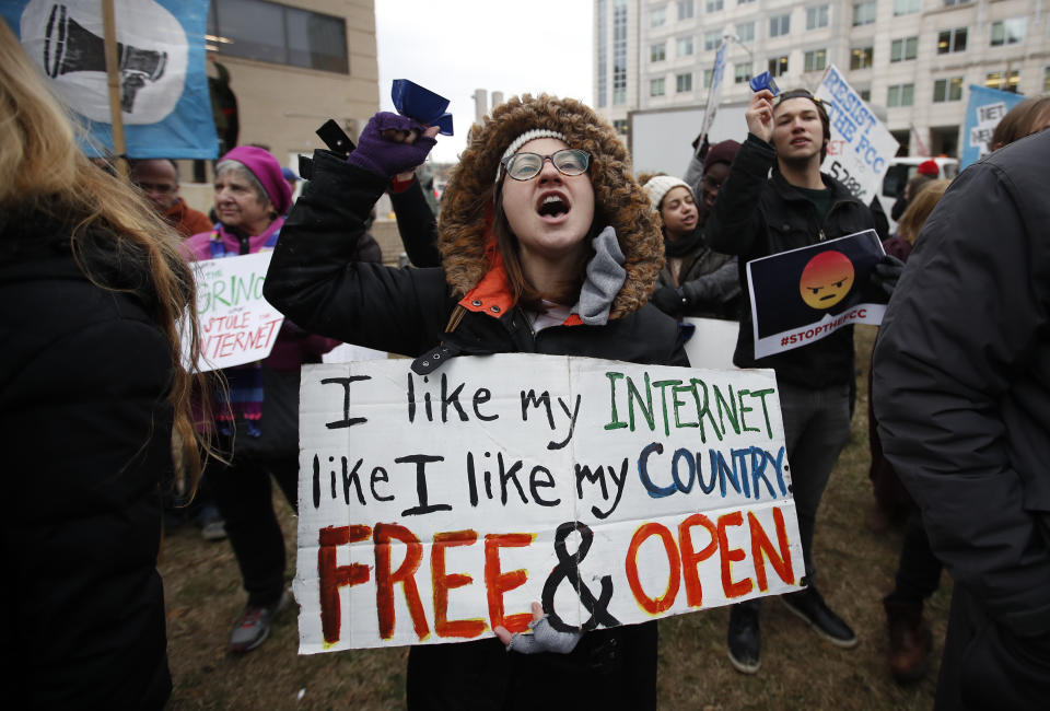 FILE - Lindsay Chestnut of Baltimore holds a sign that reads "I like My Internet Like I Like my Country: Free & Open" as she protests near the Federal Communications Commission (FCC), Dec. 14, 2017, in Washington. Telecommunications industry groups have ended their bid to block California’s net neutrality law that prevents broadband providers from throttling service. In a federal court filing in Sacramento Wednesday, May 4, 2022, the groups and California Attorney General Rob Bonta jointly agreed to dismiss the case. (AP Photo/Carolyn Kaster, File)