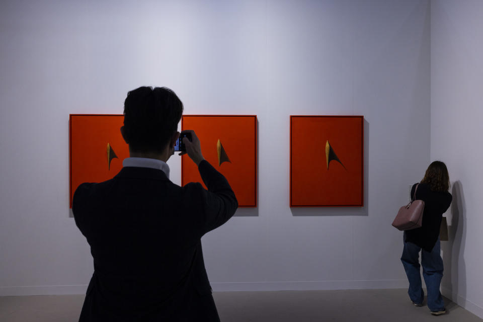 FILE - Visitors look at an artwork titled "Possibility 023-CII, CIII, CIV," created by Korean artist Song Burnsoo at the Art Basel during a preview in Hong Kong, March 21, 2023. Living in Hong Kong today means juggling contradictory feelings. In 20 interviews, many said that when they focus on business indicators and everyday life, they see a recovery gathering pace after years of travel restrictions. But when it comes to anything political, the openness and freedoms that were once hallmarks of the Chinese-ruled former British colony seem permanently gone. (AP Photo/Louise Delmotte, File)