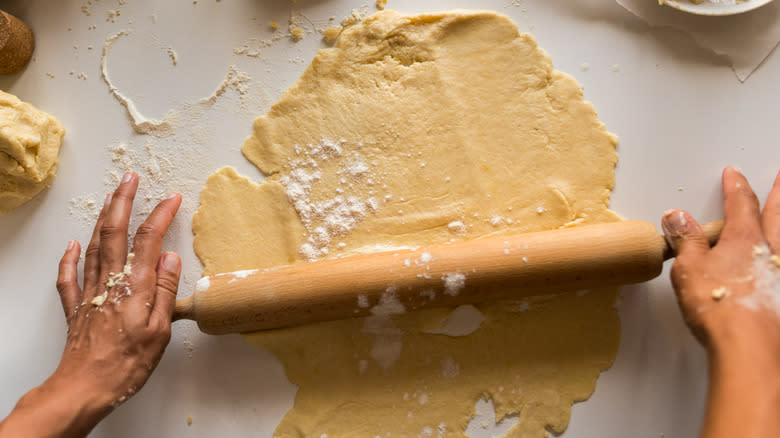 Hands rolling out pastry dough 
