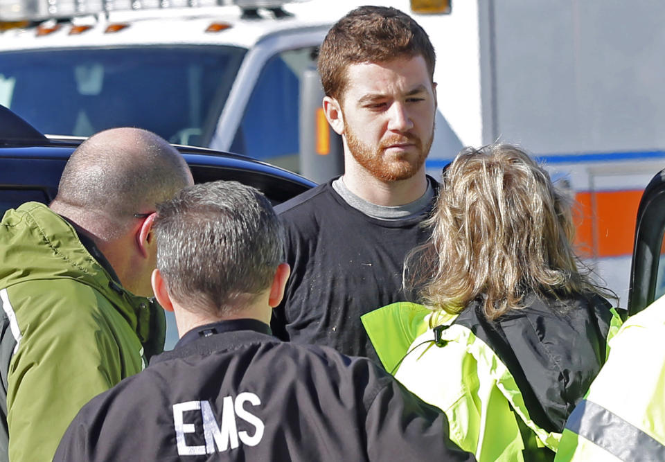 EMS personnel speak with Cody Cousins, 23, who was detained after a shooting inside the Electrical Engineering building on the campus of Purdue University in West Lafayette, Ind. Cousins, of Warsaw, Ind., is being held in the Tippecanoe County Jail on a preliminary charge of murder, accused of shooting 21-year-old Andrew Boldt of West Bend, Wis. (AP Photo/The Journal & Courier, John Terhune) MANDATORY CREDIT; NO SALES