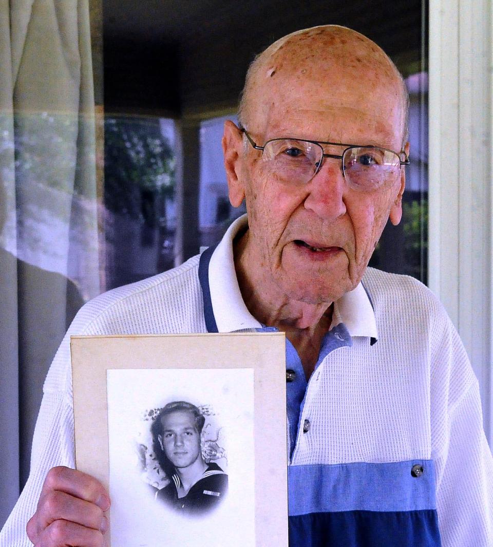 Robert Iam holds a photo of himself from when he was in the U.S. Army during WW ll. “To me, war is useless; it doesn’t solve a thing. No matter who supposedly wins, everybody loses a lot,” he says.