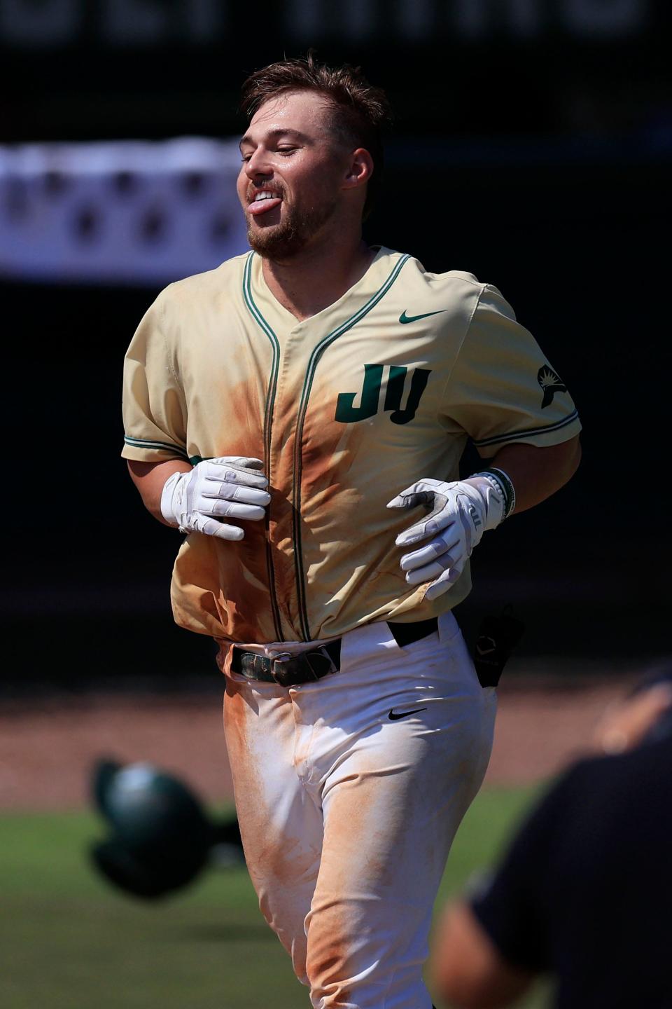 Jacksonville infielder Blake Delamielleure (23) reacts before landing on home plate for his game-winning home run on May 20.