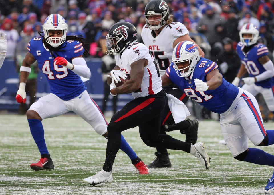 Bills Ed Oliver comes up from behind to tackle Falcons running back Mike Davis. 