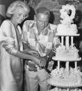 <p>Frank Sinatra and his new bride, Barbara Marx, cut into their wedding cake at the famous singer's Palm Springs ranch house in 1976.</p>