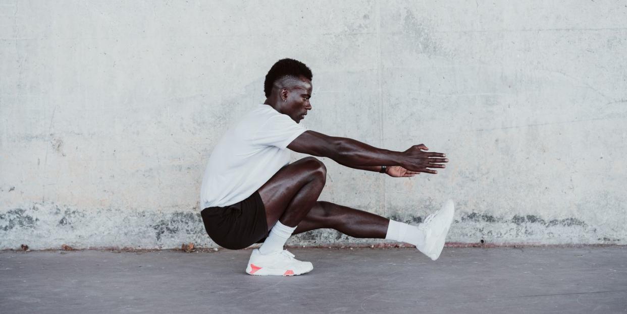 male athlete doing exercise by white wall