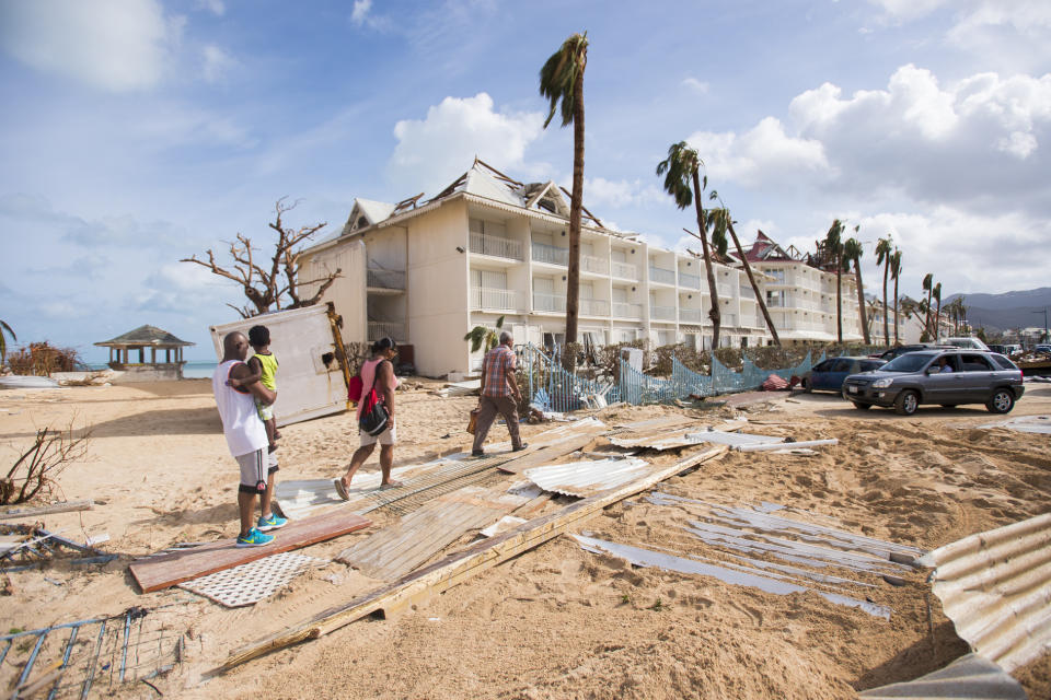 <p>People walk through damage on Sept. 7, 2017, in a sand-covered street of Marigot, near the Bay of Nettle, on the island of Saint-Martin in the northeast Caribbean, after the passage of Hurricane Irma. (Photo: Lionel Chamoiseau/AFP/Getty Images) </p>