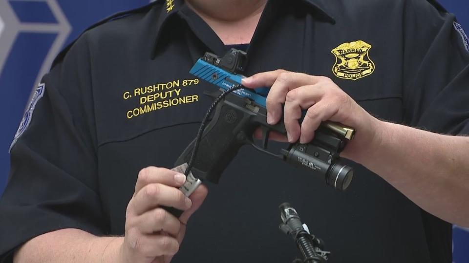 <div>Warren Police Commissioner Charles Rushton displays how to use a cable lock.</div>