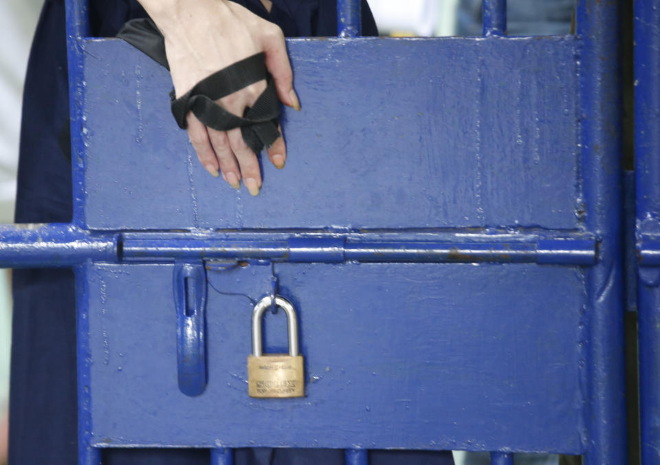 A detainee hangs his hand during an exercise session at the Bangkok immigration detention center in Bangkok, Thailand, Monday, Jan. 21, 2019. Advocates for the protection of refugees and asylum seekers lauded a commitment by Thailand on Monday to release children held in its immigration detention centers. (AP Photo/Sakchai Lalit)