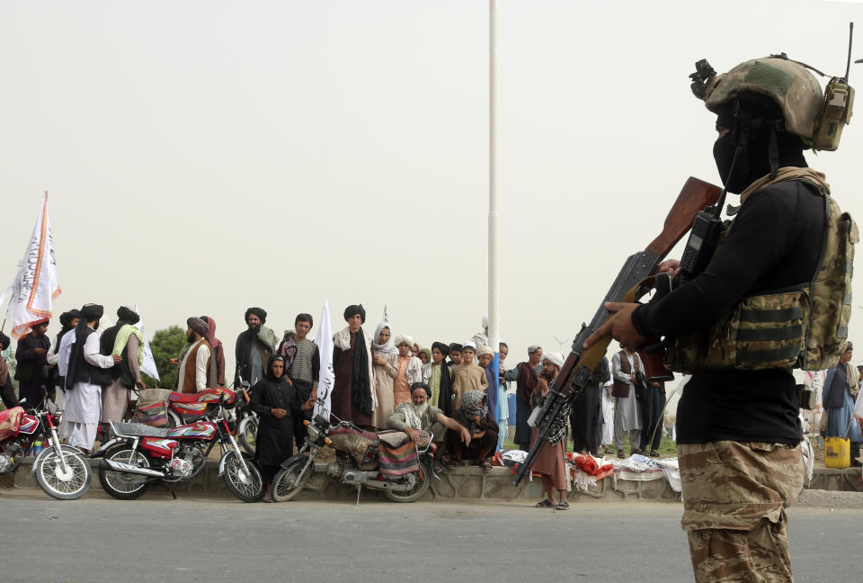 A Taliban fighter stands guard on the road during a celebration marking the second anniversary of the withdrawal of U.S.-led troops from Afghanistan, in Kandahar, south of Kabul, Afghanistan, Tuesday, Aug. 15, 2023. (AP Photo/Abdul Khaliq)