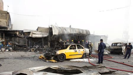 People gather at the site of a car bomb attack in Baghdad al-Jadida, Iraq April 25, 2016. REUTERS/Khalid al Mousily