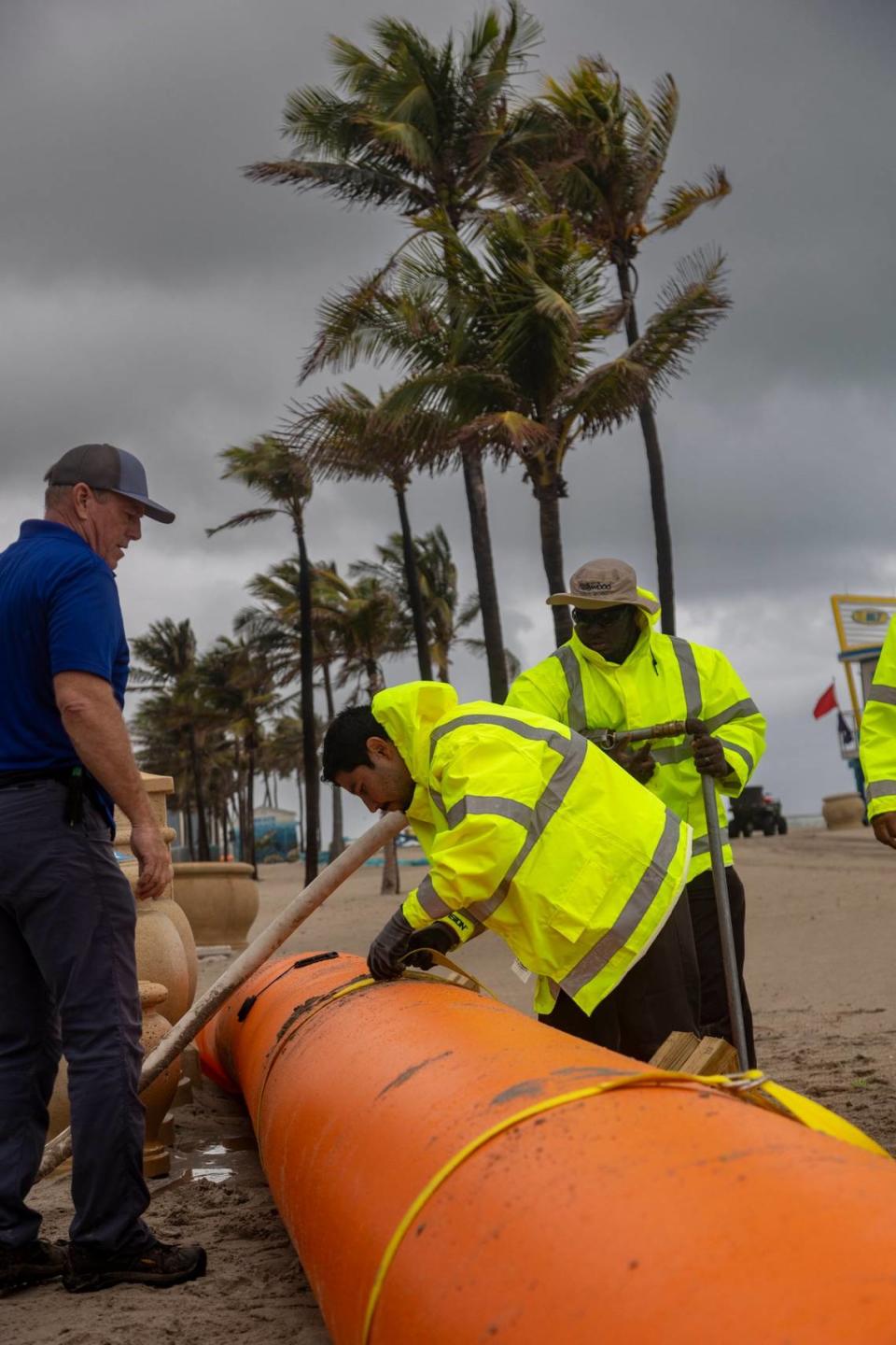 Hollywood Florida, December 13, 2023 - Workers for the City of Hollywood install a Tiger Dam at the Buchanan street entrance to Hollywood Beach. Due inclement weather, Tiger Dams have been installed on the sandy beach around the bandshell area at Johnson Street, and 3 knee wall openings to the north and 3 to the south of the band shell. Tiger Dams are a reusable water filled flood barriers that have a lifespan of 17-20 years. They come in 50ft lengths or the length can be customized. The sections can be interlocked to join together to form a seamless barrier miles long. They can be stacked to go as high as needed. The ones purchased by the City are 24” tall, and were deployed in one layer, not stacked. The Hollywood Community Redevelopment Agency (CRA) received Commission approval for the purchase at the September 6th meeting in the amount of $216,000. Delivery was just received and this is their first deployment.