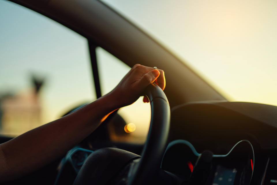 Close-up of female driver holding steering wheel in a car. Car rental. Car insurance.