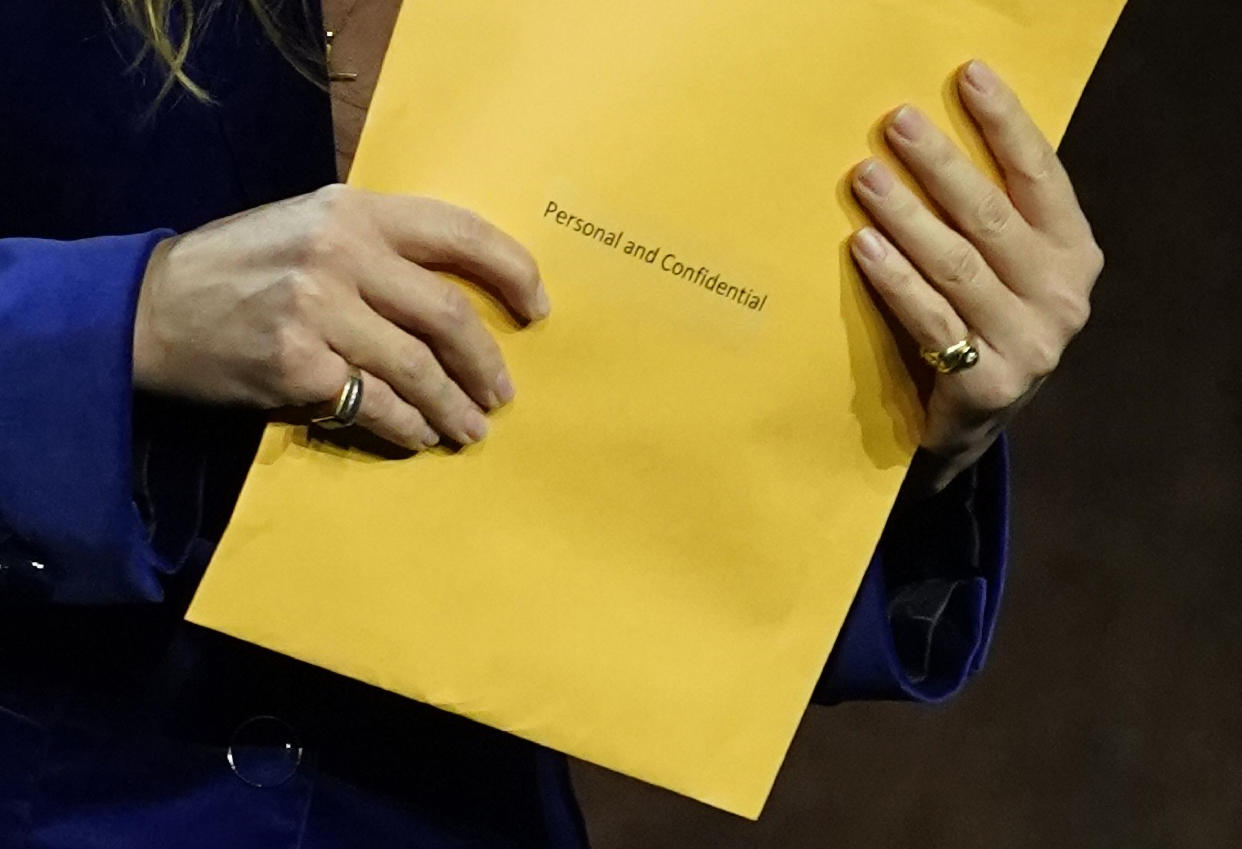 Olivia Wilde holds an envelope handed to her as she was introducing her film 