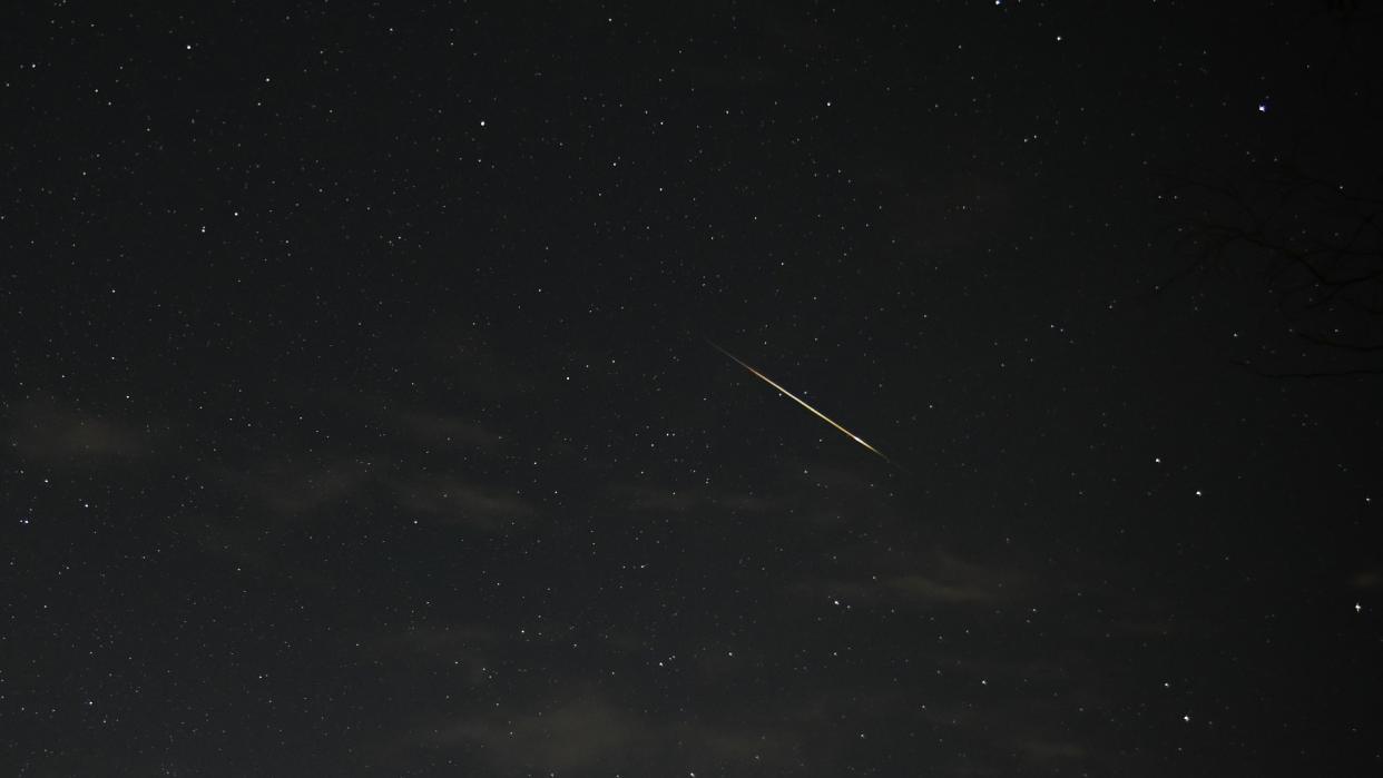  a meteor streaks across a starry night sky 