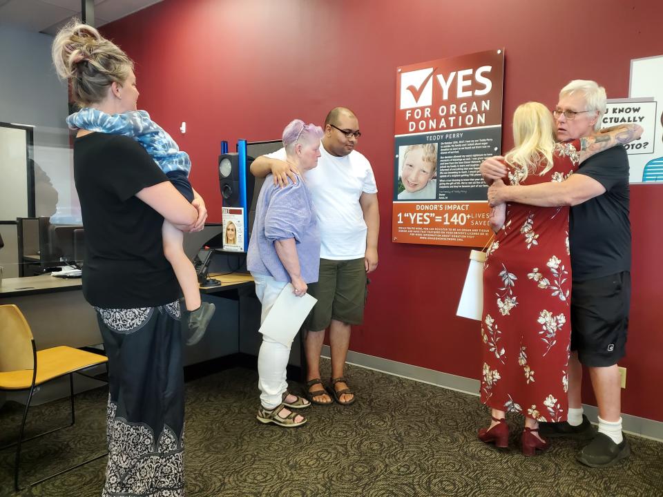 Members of Teddy Perry's family embrace after the June 29 unveiling of a plaque in his honor at the driver's license office in Ames. Perry, who died by suicide in 2017 at age 19, was an organ donor and his donations saved or improved more than 140 lives. Plaques like Perry's are meant to encourage more people to register as donors, and Perry's is the 10th such plaque at license offices in Iowa.