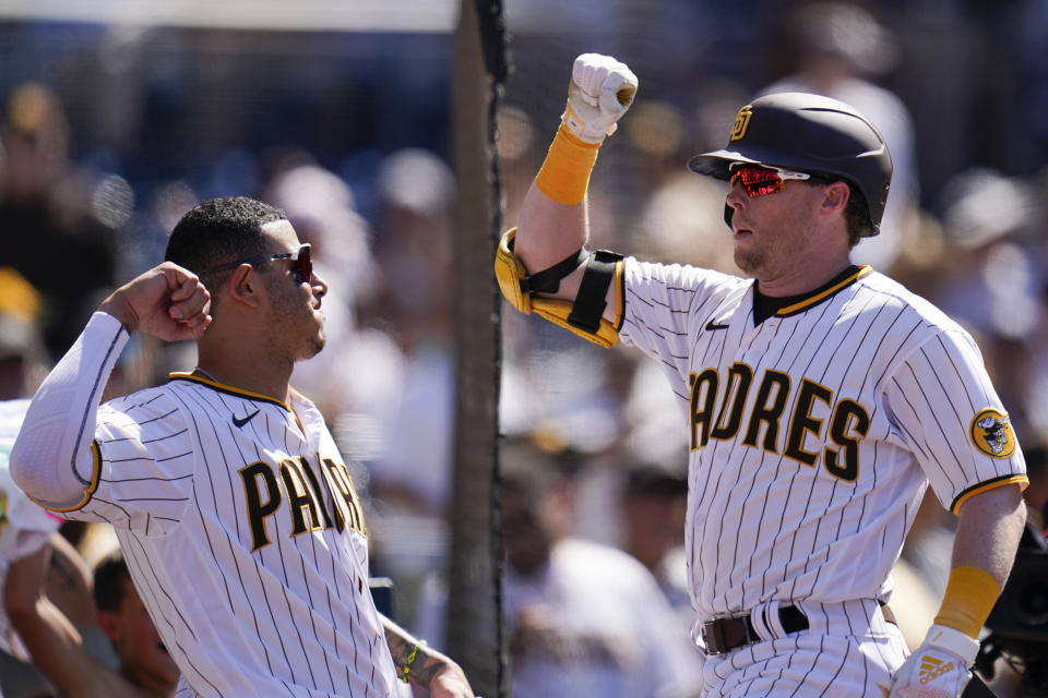San Diego Padres' Jake Cronenworth, right, celebrates with teammate Manny Machado after hitting a two-run home run during the sixth inning of the first baseball game of a doubleheader against the Colorado Rockies, Tuesday, Aug. 2, 2022, in San Diego. (AP Photo/Gregory Bull)