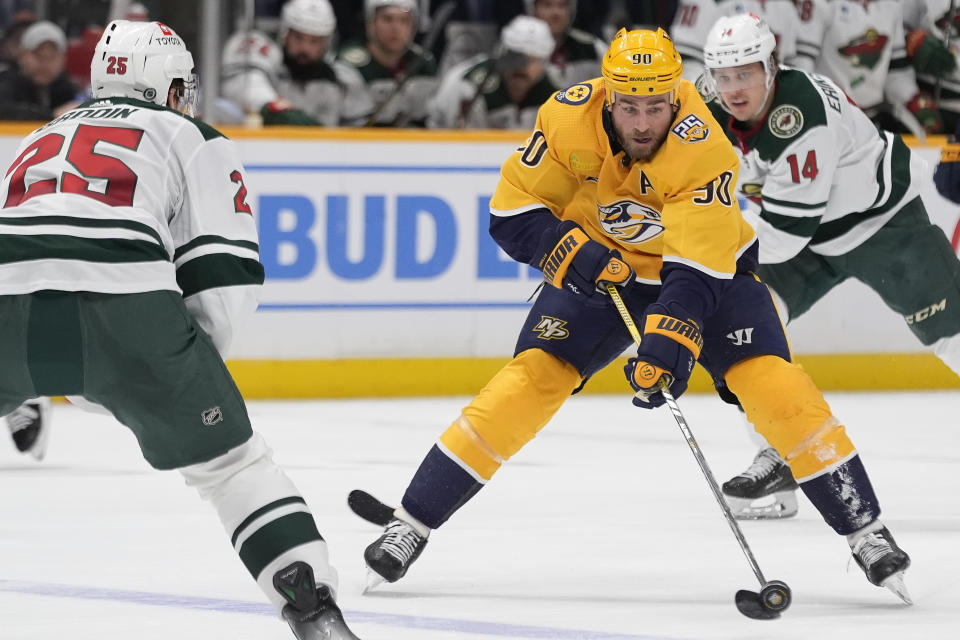 Nashville Predators center Ryan O'Reilly (90) passes the puck past Minnesota Wild defenseman Jonas Brodin (25) during the second period of an NHL hockey game Thursday, Feb. 29, 2024, in Nashville, Tenn. (AP Photo/George Walker IV)