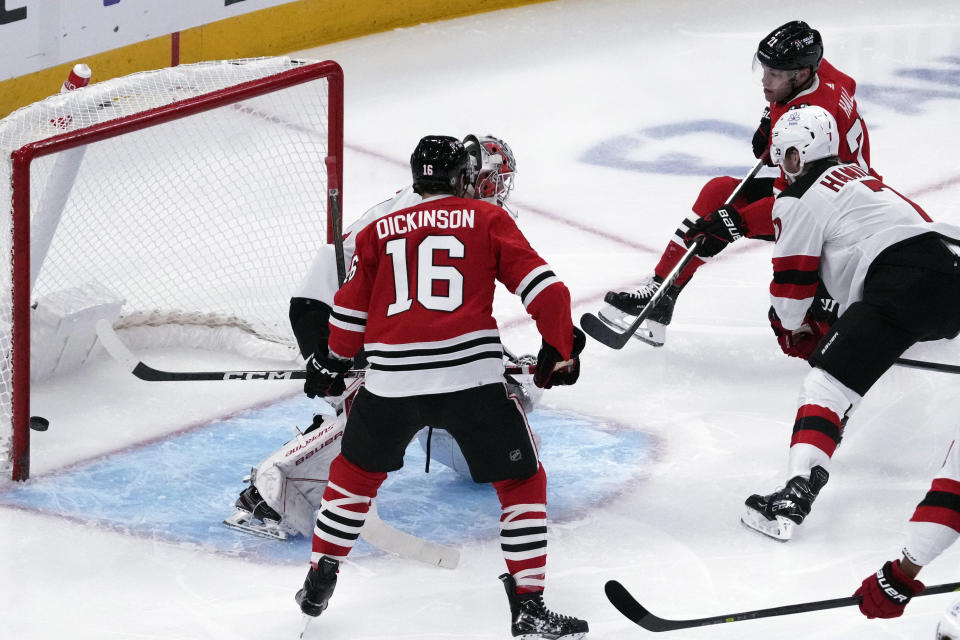 Chicago Blackhawks left wing Taylor Hall, top right, scores against New Jersey Devils goaltender Vitek Vanecek, back left, during the first period of an NHL hockey game in Chicago, Sunday, Nov. 5, 2023. (AP Photo/Nam Y. Huh)