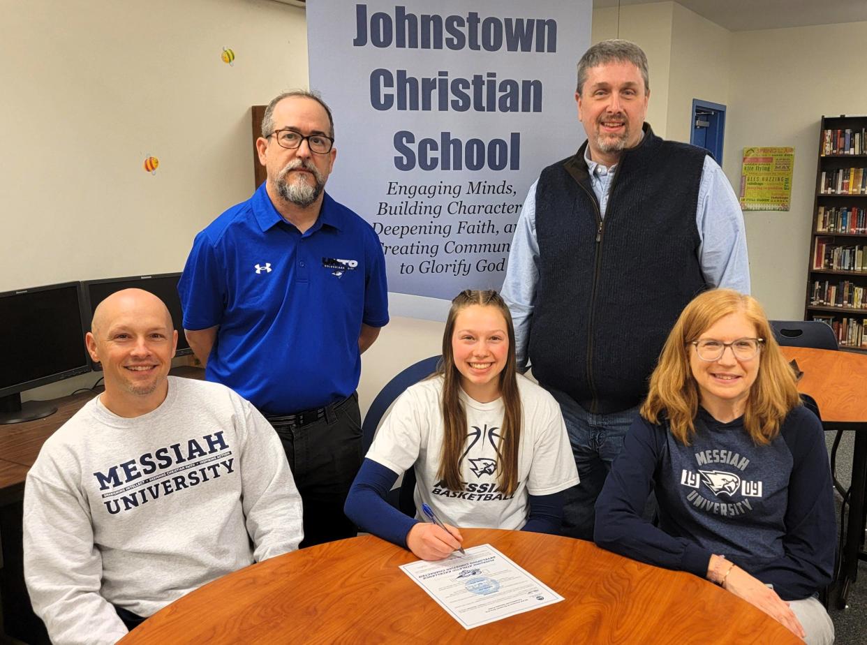 Flanked by parents Nick and Patti Miller, Johnstown Christian School senior Unity Miller announces her intentions to attend and play basketball at Messiah University, April 3, in Hollsopple. In back, from left, Johnstown Christian Athletic Director Dave Sprankle and Johnstown Christian girls basketball coach Kevin Yoder.