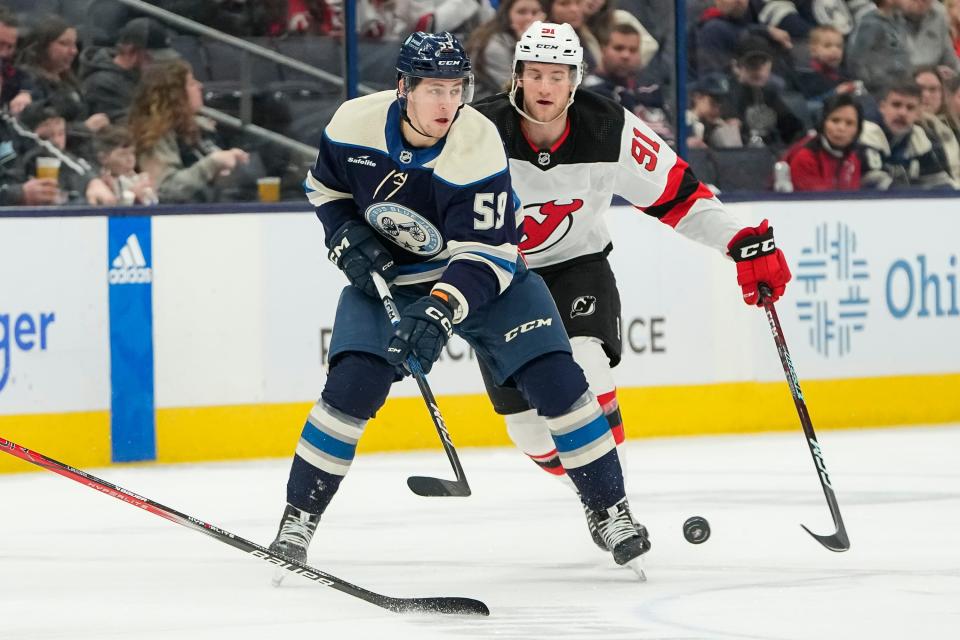 Jan 19, 2024; Columbus, Ohio, USA; Columbus Blue Jackets right wing Yegor Chinakhov (59) passes ahead of New Jersey Devils center Dawson Mercer (91) during the first period of the NHL hockey game at Nationwide Arena.