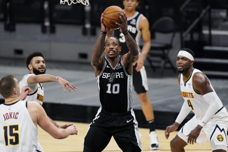 San Antonio Spurs forward DeMar DeRozan (10) shoots next to Denver Nuggets center Nikola Jokic (15) during the first half of an NBA basketball game in San Antonio, Friday, Jan. 29, 2021. (AP Photo/Eric Gay)