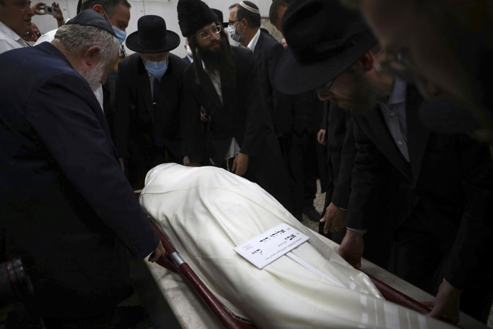 The body of Eliyahu Kay, a 26-year-old immigrant to Israel from South Africa, is surrounded by mourners during his funeral the day after he was killed when a Palestinian man opened fire in the Old City of Jerusalem, Monday, Nov. 22, 2021, in Jerusalem. (AP Photo/Oded Balilty)