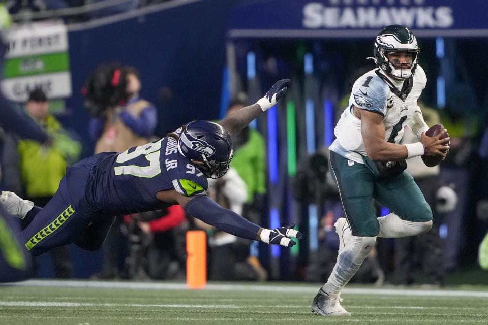 Philadelphia Eagles quarterback Jalen Hurts, right, runs for yardage as Seattle Seahawks defensive end Mario Edwards Jr. (97) tries to stop him during the first half of an NFL football game, Monday, Dec. 18, 2023, in Seattle. (AP Photo/Lindsey Wasson)