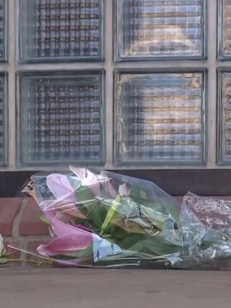 Woman lays flowers at police station. Picture 7News.JPG