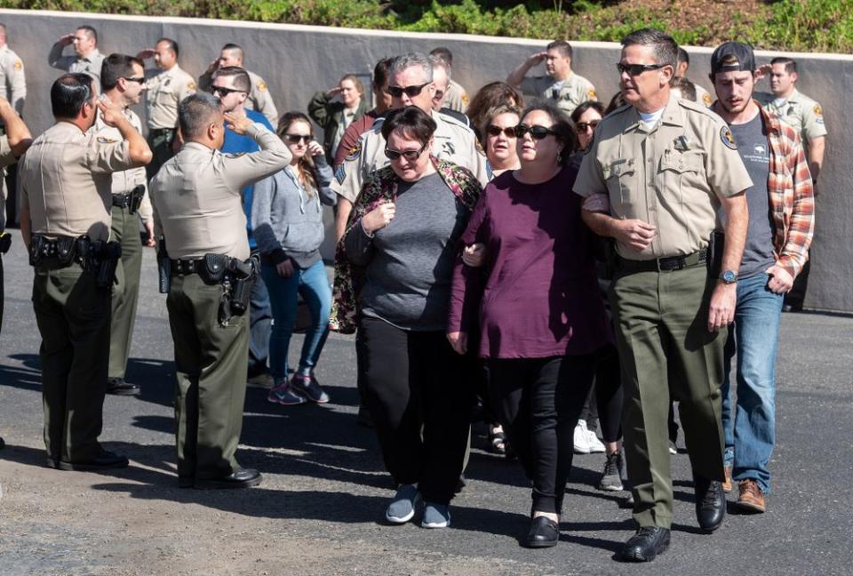 Sgt. Ron Helus' wife and family mebers are escorted from Los Robles Hospital behind his casket